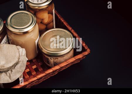 Geschenkkorb mit Gourmet-Produkten, Gläsern und Konserven lokaler Produkte. Landwirtschaftliche Produkte Stockfoto