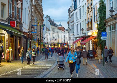 BRÜSSEL, BELGIEN - 06. OKTOBER 2019: Menschenmenge, die in der Dämmerung an der Einkaufsstraße der Altstadt von Brüssel spazieren Stockfoto