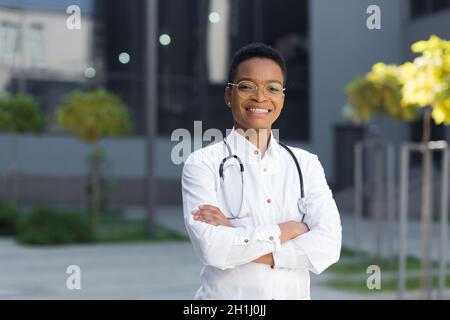 Porträt der weiblichen Kinderarzt Arzt glücklich erfolgreich lächelnd und Blick auf Kamera in der Nähe der Klinik im medizinischen Kleid Stockfoto