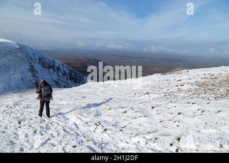 CO KERRY, IRLAND - Februar 4, 2019: Frau klettern in den Schnee auf die Brüste von Anu, Co Kerry, Irland Stockfoto