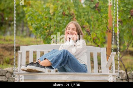 Entspannung im Park. Sommerliche Aktivität. Positive Emotionen. Nettes Kind auf Schaukel. Kind im Freien schwingen. Stockfoto