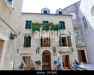 Kotor, Montenegro - 07. Mai 2014: Menschen gehen in der Nähe des Hotels auf dem St. Luke-Platz, umgeben von traditionellen Steinhäusern in der Altstadt von Kotor, Montenegro Stockfoto