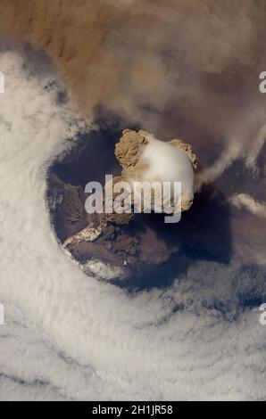 Die Erde von der Internationalen Raumstation aus gesehen: Sarychev Peak Eruption, Kuril Islands. In einem frühen Stadium des Ausbruchs am 12. Juni 2009. Der Sarychev Peak ist einer der aktivsten Vulkane der Kuril-Inselkette und liegt am nordwestlichen Ende der Insel Matua. Das Bild zeigt mehrere Phänomene, die während der frühesten Stadien eines explosiven Vulkanausbruchs auftreten. Die Hauptsäule ist eine einer Reihe von Federn, die am 12. Juni über Matua Island stiegen. Eine optimierte und verbesserte Version eines NASA-Bildes / Credit NASA. Stockfoto