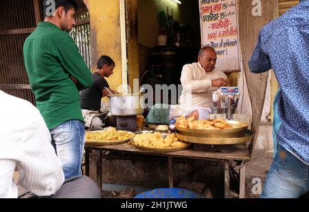 Ein indischer Ladenbesitzer, der in einer Straße in Pushkar, Rajasthan, Indien, gebratenes Street Food verkauft Stockfoto