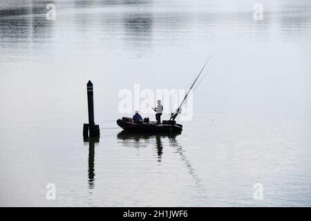 Silhouette des Fischens Schlauchboot und Fischer auf See im Morgensommer Stockfoto