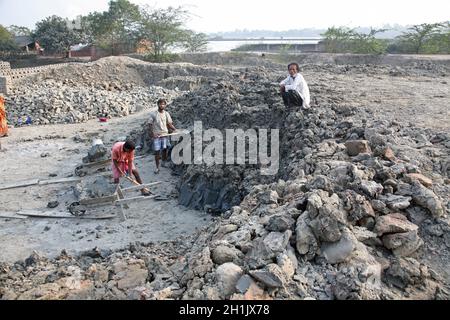 Ziegelfeld. Arbeiter tragen abgelagerte Böden für die Herstellung von rohem Ziegel in Sarberia, Westbengalen, Indien. Stockfoto