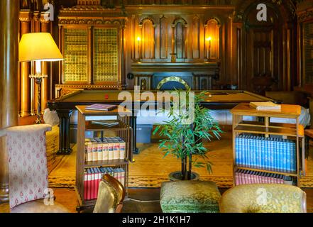 Ein wunderschön eingerichtetes Bibliothekszimmer im Penrhyn Castle, einem weitläufigen Landhaus in Llandygai, Bangor, Wales, Großbritannien Stockfoto