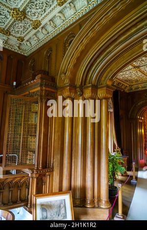 Ein wunderschön eingerichtetes Bibliothekszimmer im Penrhyn Castle, einem weitläufigen Landhaus in Llandygai, Bangor, Wales, Großbritannien Stockfoto