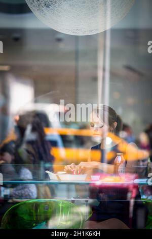 Hübsche, junge Frau Sushi essen in einem Restaurant, in der Mittagspause, genießen das Essen, Pausen für eine Weile aus ihrem ereignisreichen Leben (Corporate/Büro Stockfoto