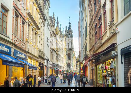 BRÜSSEL, BELGIEN - 06. OKTOBER 2019: Menschenmenge, die durch die Altstadt-Einkaufsstraße von Brüssel läuft, Grand Place im Hintergrund Stockfoto