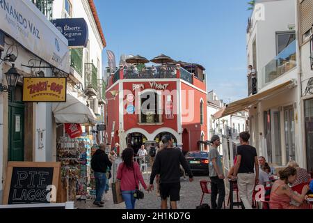 LAGOS, PORTUGAL - 18. September 2020: Touristen gehen, essen in Restaurants in der Altstadt von Lagos. Die Straßen bieten viele Geschäfte, Cafés und Eis BA Stockfoto