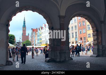 Schöne Aussicht auf die Stadt Danzig von alten Bögen. Touristen spazieren im Freien in Danzig mit schönem Blick auf die Straße im Stadtbogen. Panorama von der Stadt ar aus gesehen Stockfoto