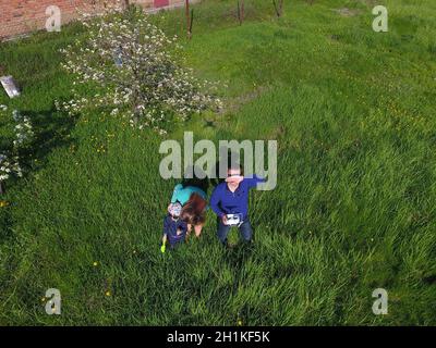 Ein Mann und eine Frau werden von einer Drohne auf einer grünen Lichtung fotografiert Stockfoto