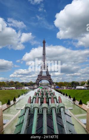 Der Eiffelturm in Paris von der Seite des Trocadero-Platzes und der Trocadero-Brunnen auf einem Hintergrund von blauem Himmel und Wolken. Stockfoto