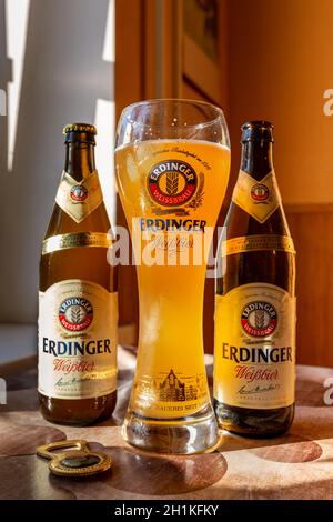 Erdinger Bier wird in einem Markenbierglas und zwei Flaschen Bier auf der Seite gegossen. Erdinger Bier auf dem Tisch. 04.07.2015 Kiew Ukraine Stockfoto