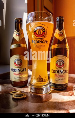 Erdinger Bier wird in einem Markenbierglas und zwei Flaschen Bier auf der Seite gegossen. Erdinger Bier auf dem Tisch. 04.07.2015 Kiew Ukraine Stockfoto