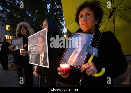 London, Großbritannien. Oktober 2021. Anhänger des Nationalen Widerstandsrates des Iran (NCRI) halten Bilder und Kerzen hoch, um Sir David Amess zu ehren, der in der vergangenen Woche mehrmals bei einer Wahlkreisoperation in Leigh on Sea tödlich erstochen wurde, Essex.Anglo-iranische Gemeindemitglieder hielten eine Gedenkfeier und Mahnwache vor dem Parlament ab, um dem ermordeten Abgeordneten Sir David Amess zu Tribut zu zollen. Kredit: SOPA Images Limited/Alamy Live Nachrichten Stockfoto