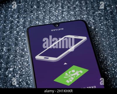 LOD, Israel - 8. Juli 2020: RAV Kav Online App Launch Screen mit Logo im hebräischen Text auf dem Display eines schwarzen mobilen Smartphones auf einem metallischen Backgr Stockfoto