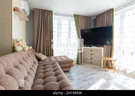 Anapa, Russland - 23. August 2020: Geräumiges Schlafzimmer mit einem riesigen Sofa und TV Stockfoto