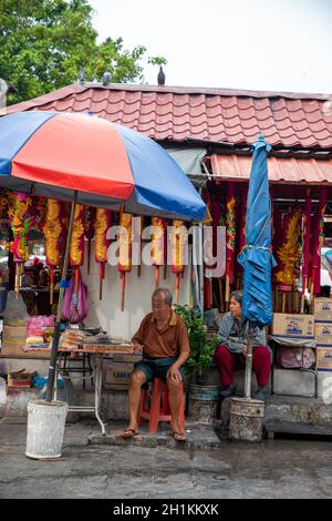 Georgetown, Penang/Malaysia - 07 2016. Aug: Hawker sitzen am Joss Stick Stand. Stockfoto