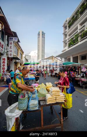 Georgetown, Penang/Malaysia - 07 2016. Aug: Frau kauft Essen auf dem Morgenmarkt. Zurück ist KOMTAR Gebäude. Stockfoto