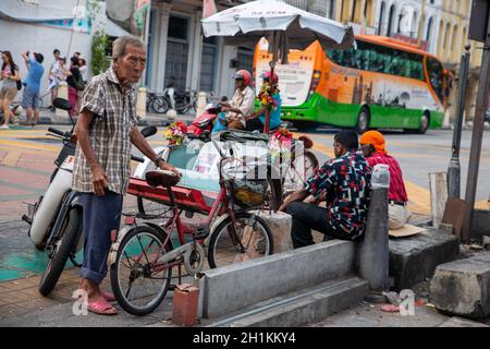 Georgetown, Penang/Malaysia - Aug 07 2016: Ein alter Mann steht neben dem Fahrrad auf der Straße. Stockfoto