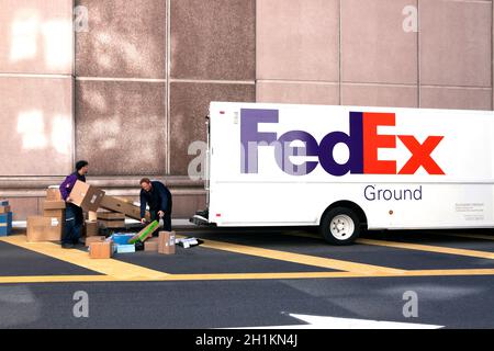 FedEx-Zustellkräfte sortieren auf der Straße die Kartons aus. Stockfoto
