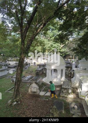 George Town, Penang/Malaysia - Nov 15 2019: Sauberer die Blätter auf dem protestantischen Friedhof Stockfoto