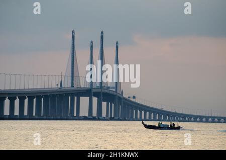 George Town, Penang/Malaysia - Dez 28 2019: Ein seufzender Boot fährt in Richtung der Hauptspannweite der Penang Second Bridge. Stockfoto