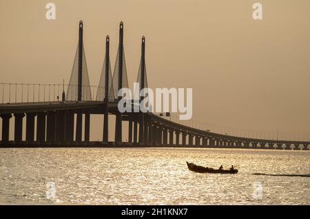 George Town, Penang/Malaysia - Dez 28 2019: Fischerboot bewegt sich in der Nähe der Penang Second Bridge. Stockfoto