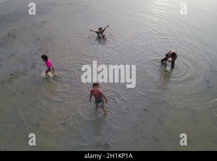 Penaga, Penang/Malaysia - Nov 03 2019: Asiatisch-malaysische Kinder spielen schlammig im Reisfeld. Stockfoto