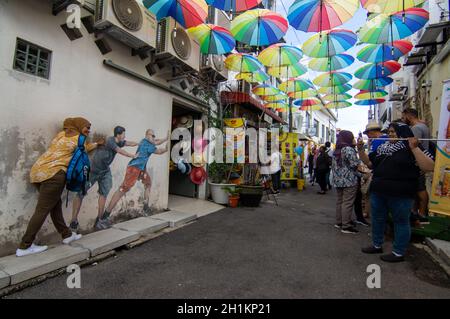 George Town, Penang/Malaysia - Nov 11 2019: Tourist posiert vor Mural auf der Straße. Stockfoto