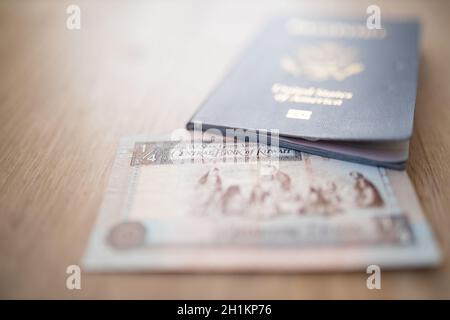 Bild von der Ecke eines Kuwait Quarter Dinar in einem verschwommenen US-amerikanischen Pass Stockfoto