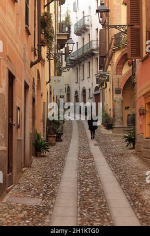 Eine kaukasische Frau spaziert entlang der Citiscape von Acqui Terme, dem berühmten italienischen Kurort. Foto von Hires. Stockfoto