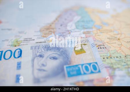 Bild von Schweden auf einer verschwommenen europäischen Karte mit einer schwedischen Kronenbanknote von 100 - mit den Worten hundert Kronen auf Schwedisch - oben Stockfoto