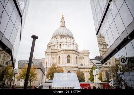 London, Großbritannien - 15. Oktober 2020: Landschaftsansicht der Saint Paul Cathedral unter einem bewölkten Himmel und zwischen zwei dunklen Glasgebäuden in London, Großbritannien Stockfoto