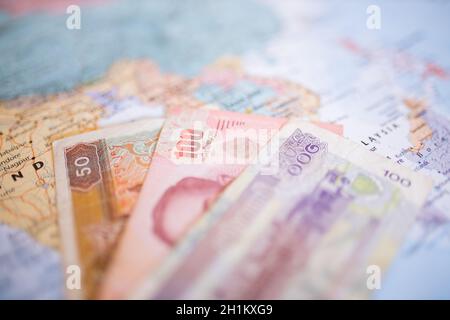 50 burmesische Kyat-Banknote, eine thailändische Baht-Banknote von 100 und eine 100-Riels-Banknote neben Myanmar, Thailand und Kambodscha auf einer Karte Südostasiens Stockfoto