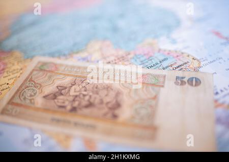 Nahaufnahme der Rückseite einer fünfzig burmesischen Kyat-Banknote neben Myanmar auf einer farbenfrohen und verschwommenen Karte Südasiens Stockfoto