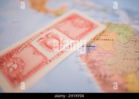 Rückseite einer Banknote mit fünf ecuadorianischen Sucrets - mit dem Wort Bank auf Spanisch - neben Ecuador auf einer Landkarte von Südamerika Stockfoto