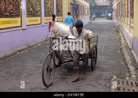 Traditioneller, handgezogener, indischer Rikscha-Fahrer, der auf der Straße in Kalkutta arbeitet Stockfoto