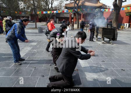 Gläubige, die Räucherstäbchen halten, beten im Yonghegong Lama Tempel in Peking, China Stockfoto