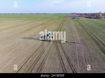 Traktor mit aufklappbaren Sprühen von Pestiziden. Düngung mit einem Traktor, in Form eines Aerosols auf dem Gebiet der Winterweizen Stockfoto