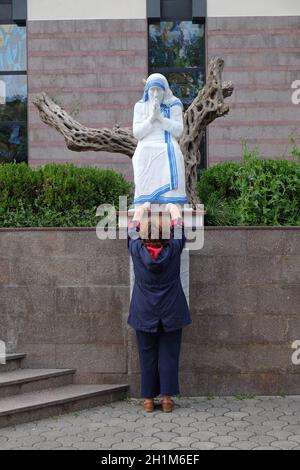 Eine Frau betet vor der Statue des Hl. Mutter Teresa vor St. Paul's Cathedral in Tirana, Albanien Stockfoto