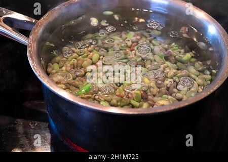 Ein Topf mit grünen Bohnen, der in einem Topf mit Wasser blanchiert wird. Stockfoto