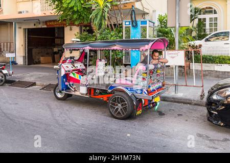 Bangkok, Thailand - 7. Dezember 2019: Tuk-Tuk-Fahrer schläft in seinem Fahrzeug, bevor der nächste Kunde in Bangkok, Thailand, auf die Straße springt. Stockfoto