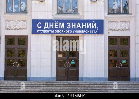 Wolgograd, Russland - 26. August 2019: Die Inschrift "glücklicher Wissenstag, Studenten der Flaggschiff-Universität!" An der Fassade des Gebäudes der Stockfoto