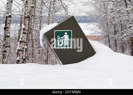 Ein Müllcontainer mit Hinweisschild im Winter. Stockfoto