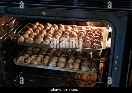 Beim Backen von zwei Schalen mit Fleischbällchen im Ofen. Stockfoto