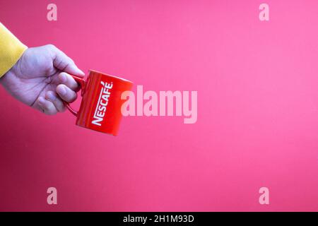 Kuala Lumpur, Malaysia - 12. November 2020 : Hand haltenden Nescafe Becher auf rotem Hintergrund Stockfoto