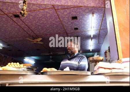 Ein indischer Ladenbesitzer, der in einer Straße in Pushkar, Rajasthan, Indien, gebratenes Street Food verkauft Stockfoto